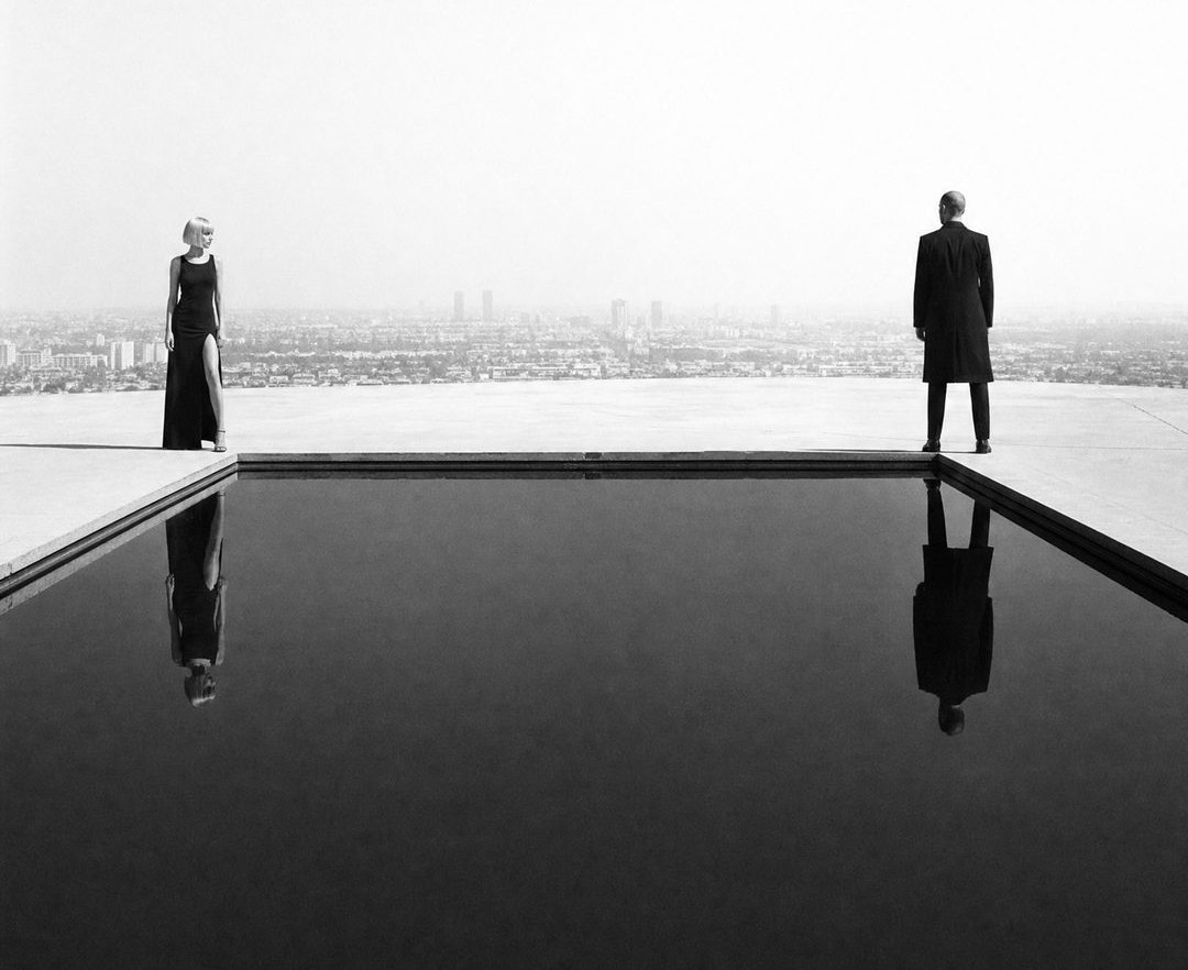 Ein Mann steht am Rand eines Pools hoch über einer Stadt